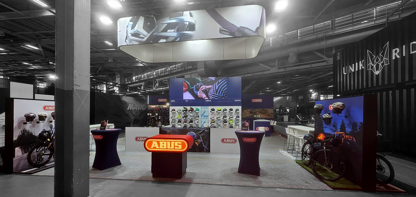 80 m² ABUS booth at the Prodays trade show, featuring a wall of bike locks and mountain bike floor displays