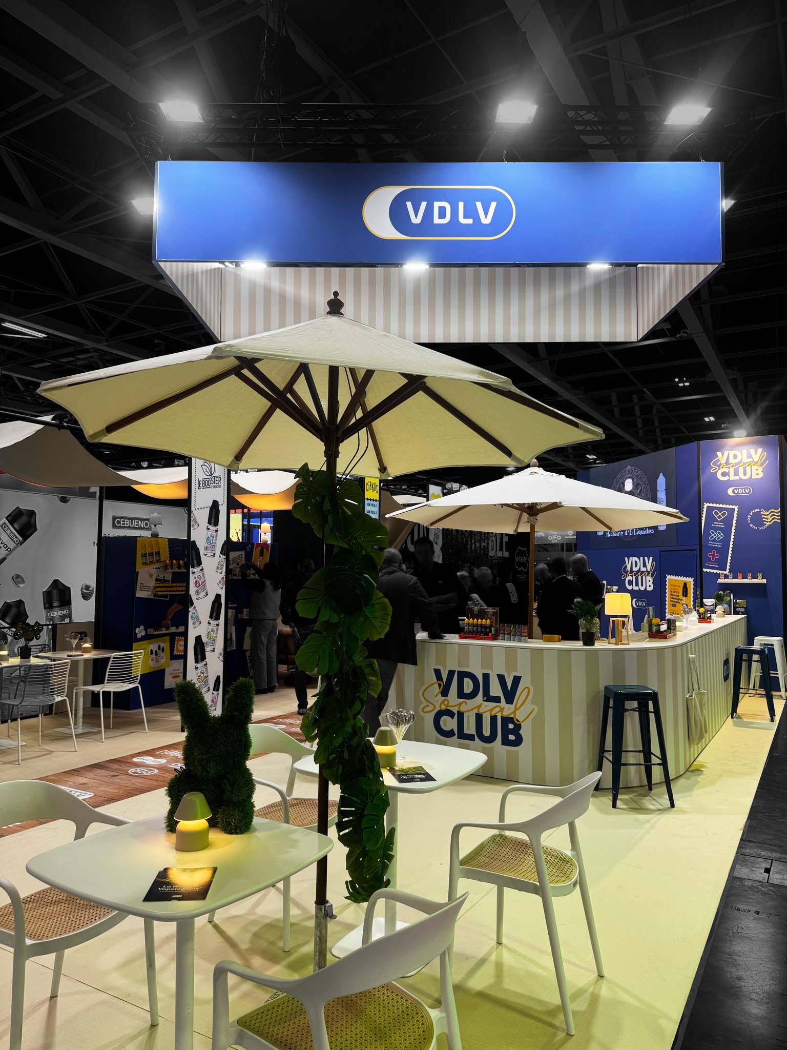 VDLV booth: close-up of the meeting area with a parasol and a bar in the background