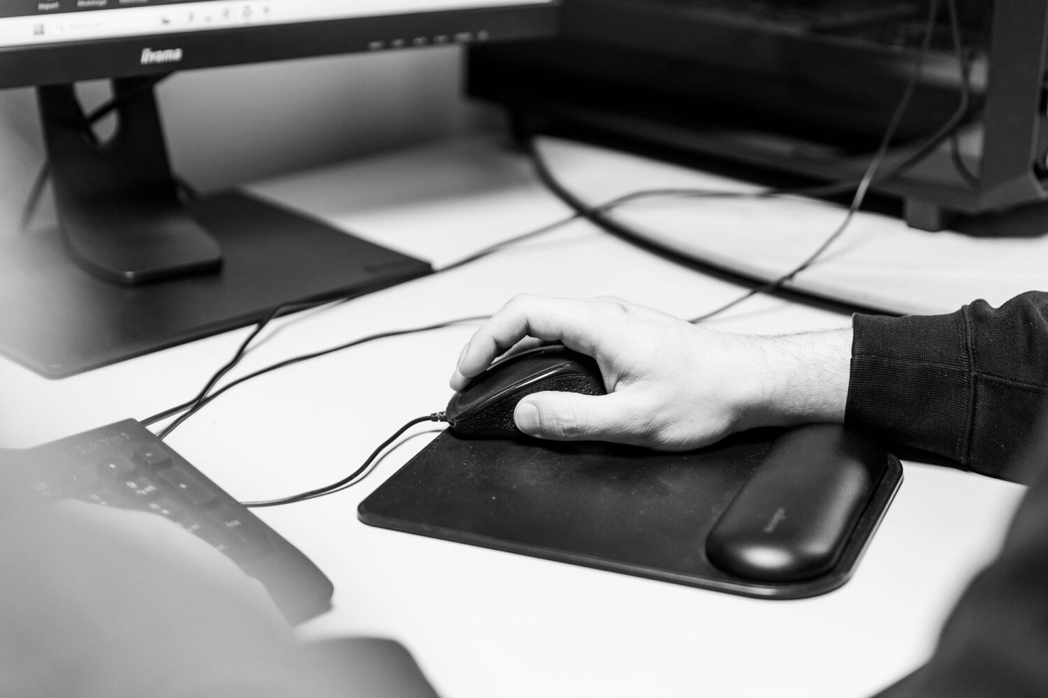 Main sur la souris pendant la modélisation 3D d'un stand au bureau d'études ENJOY