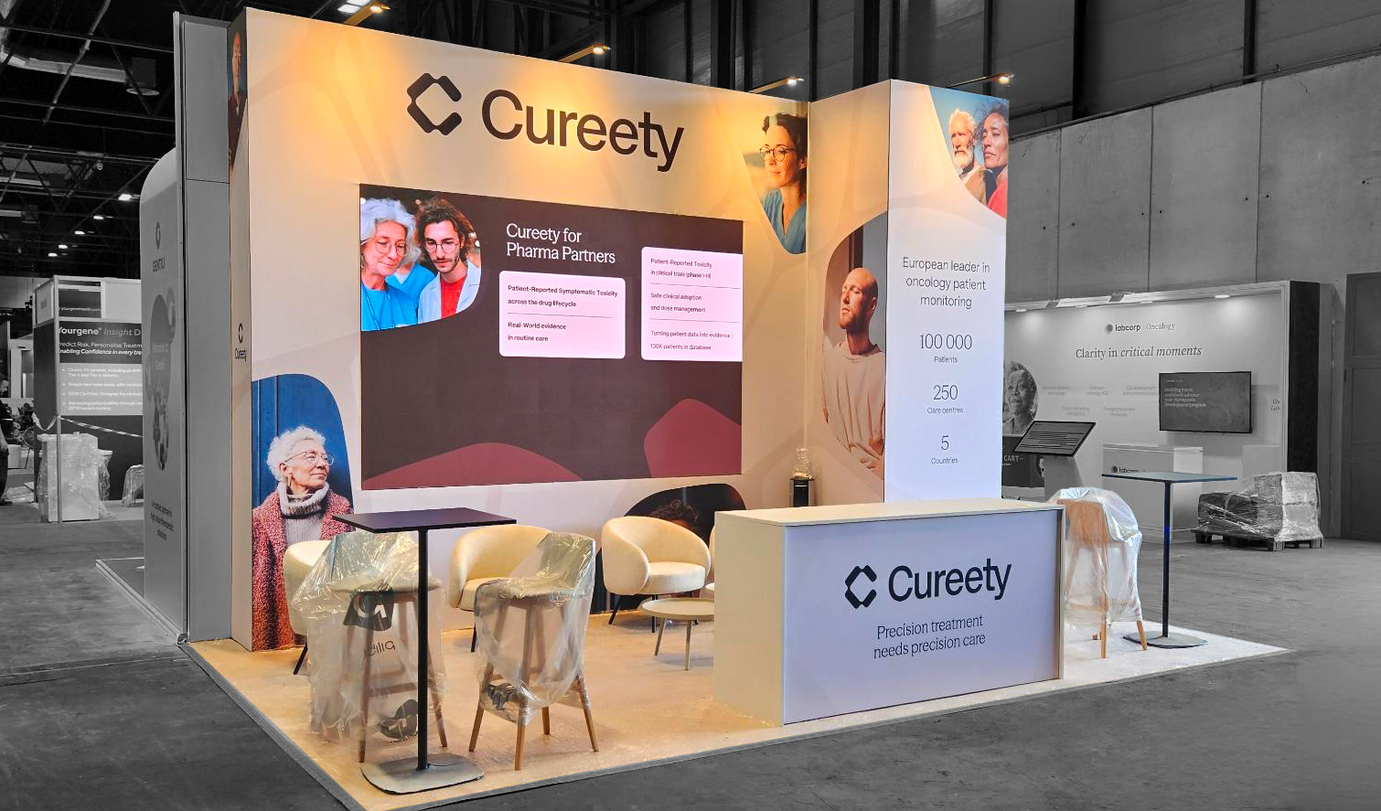 Cureety booth at the ESMO Congress in Madrid, corner view and lounge area with armchairs